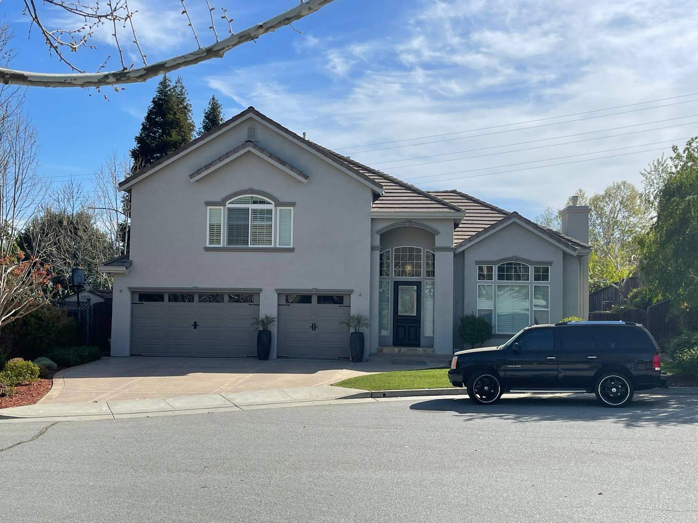 Gray two-story home with two garage doors, freshly painted