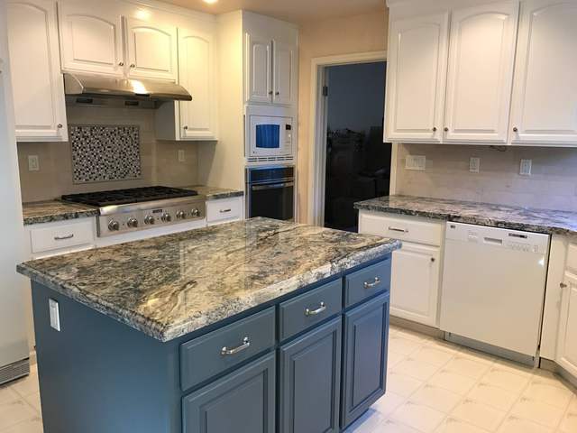 Finished kitchen with white uppers and a blue island