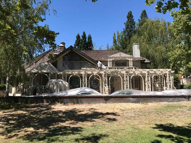 Large home on a wooded lot during painting