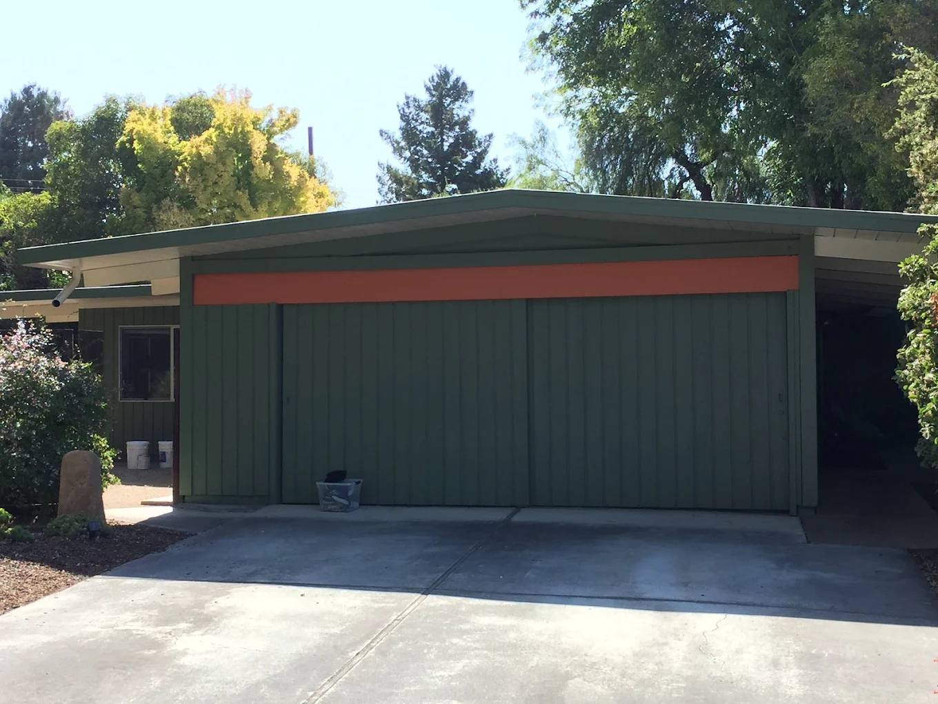 Mid-century home with a garage painted olive green and orange trim