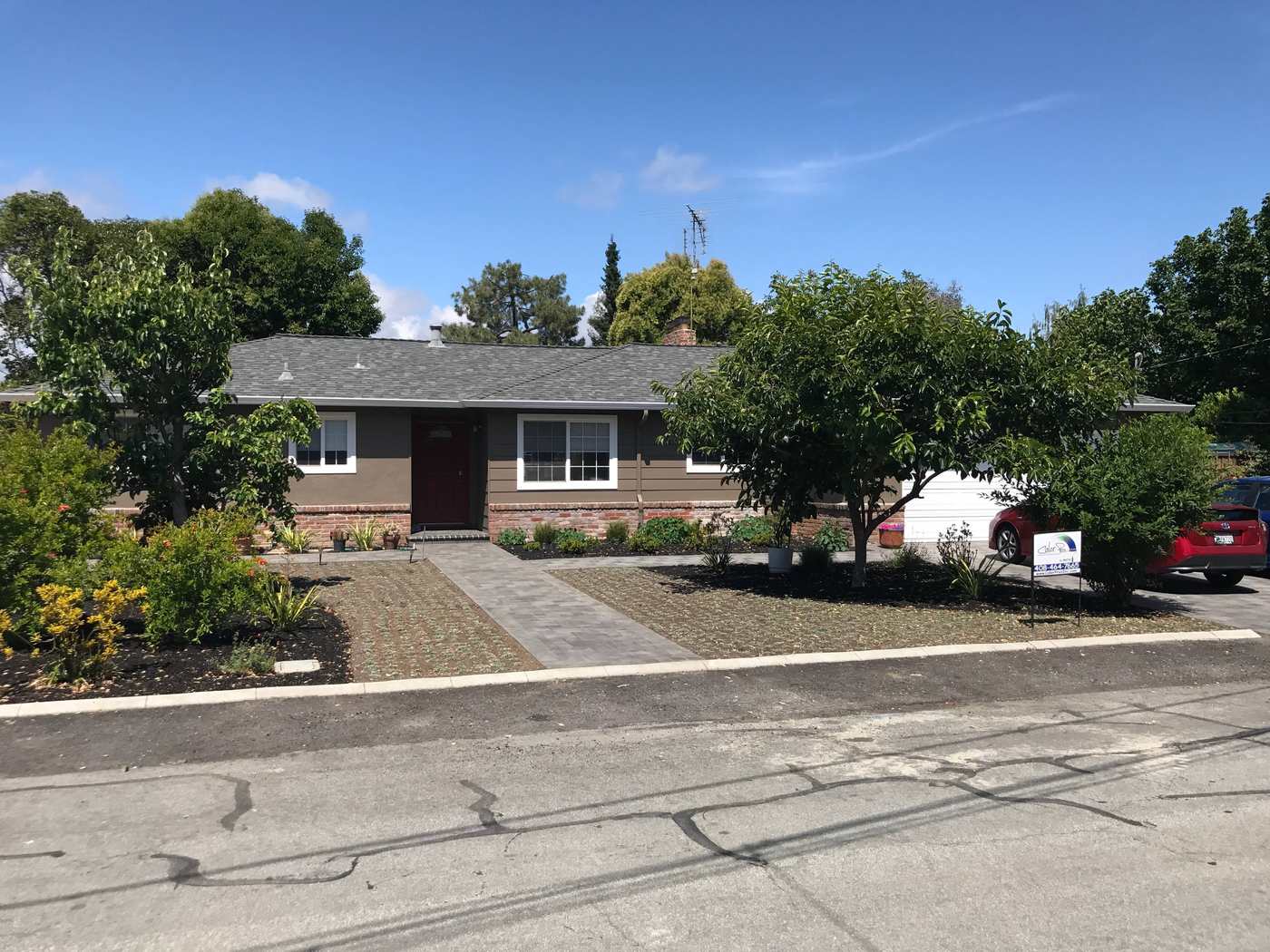 Single-story ranch home repainted, with mature trees in the front yard