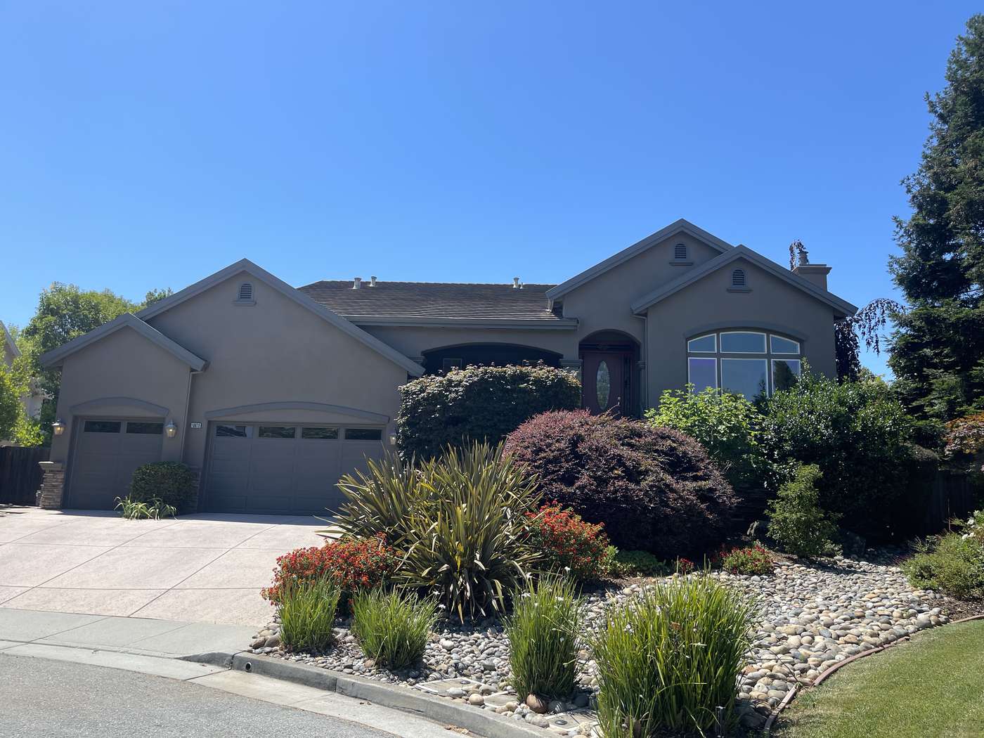 Two-story home with a new exterior color and matching garage doors