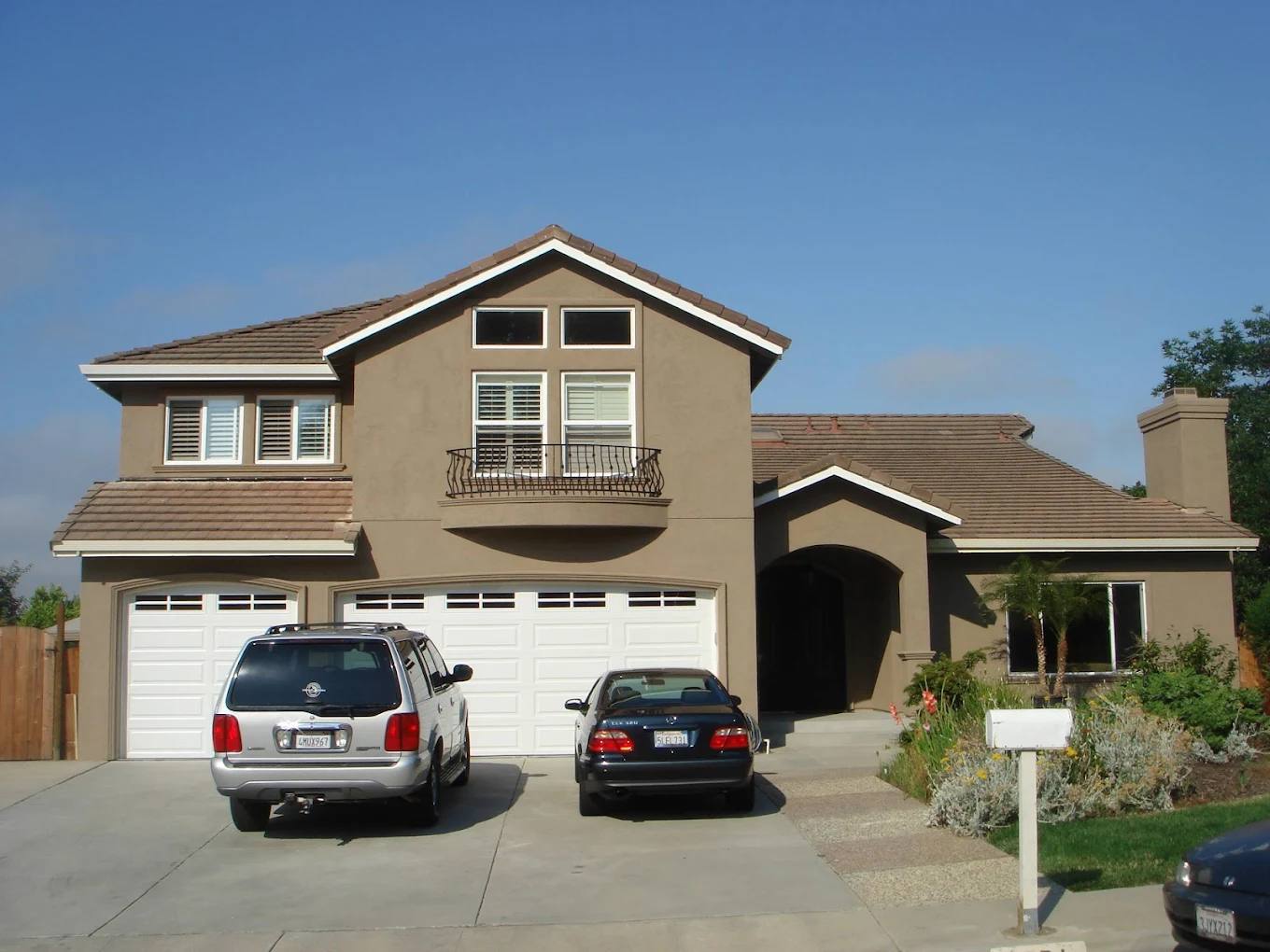 Two-story tan home repainted with white trim