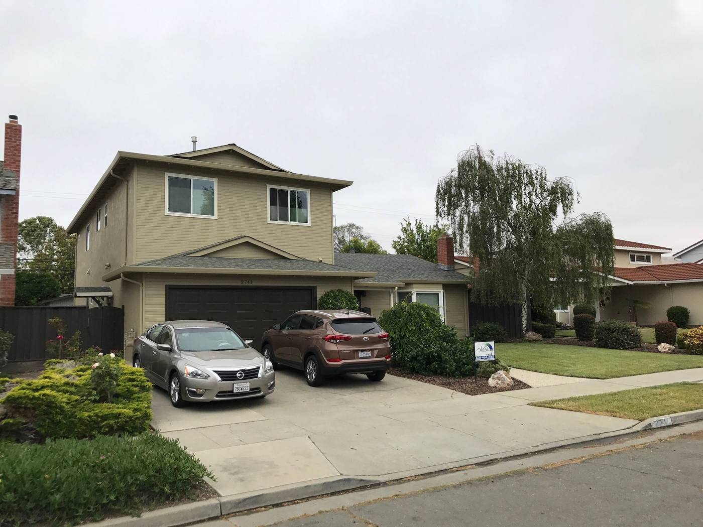 Two-story tan home with a fresh exterior paint job